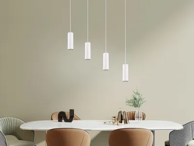 A dining table with chairs and pendant lights hanging above.