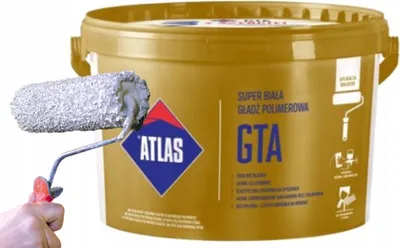 A bucket of gold-colored polymer filler with a paint roller in the foreground.