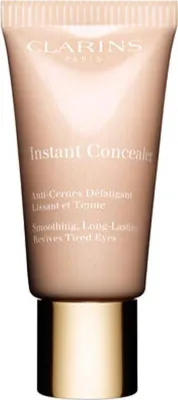 A close-up studio shot of a Clarins Instant Concealer tube with a gold cap.