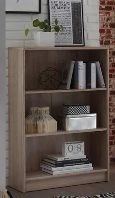 A bookshelf with various decorative items and books on its shelves, set against a brick wall.