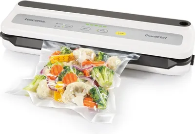 A vacuum sealer machine with a bag of vegetables being sealed.