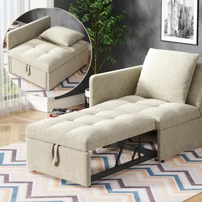 A beige sofa bed is shown in a living room setting with a plant and artwork in the background.