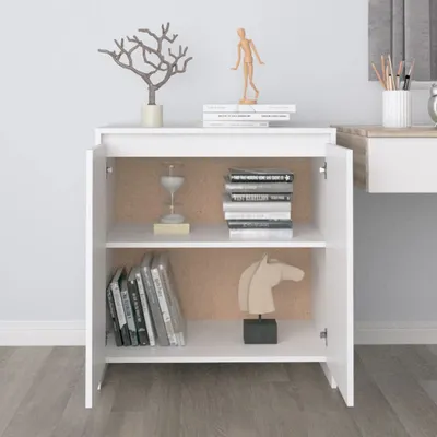 A white sideboard with open doors, displaying books and decorative items on its shelves.