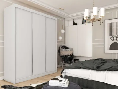 A bedroom scene featuring a large white wardrobe, a bed with dark bedding, a chair with cushions, and decorative elements on the wall.