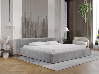 A modern bedroom with a large grey upholstered bed as the main focus, decorated with abstract wall art and soft lighting.