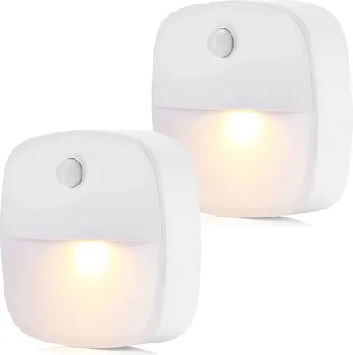 Two white LED night lights with motion sensors are shown against a white background.