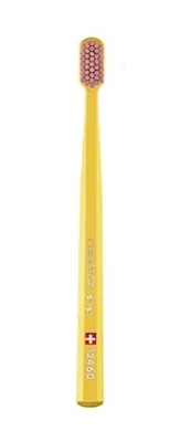 A yellow toothbrush with pink bristles is shown against a white background.