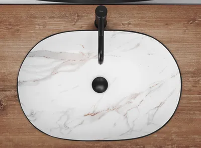A top-down view of a marble-patterned sink with a black faucet and drain.