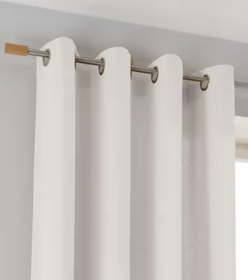 A close-up view of white curtains hanging from a curtain rod.