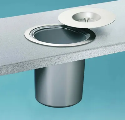 A built-in trash can with a lid on a countertop.