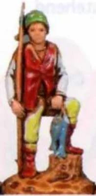 Eine Figur, die einen Jäger oder Fischer darstellt. Er trägt bunte Kleidung und eine lange Stange.