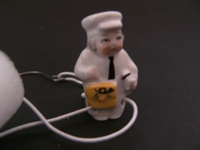 Produktbild von Porzellan Tropfenfänger Briefträger, handbemalt für Kaffee- oder Teekannen Figur Post