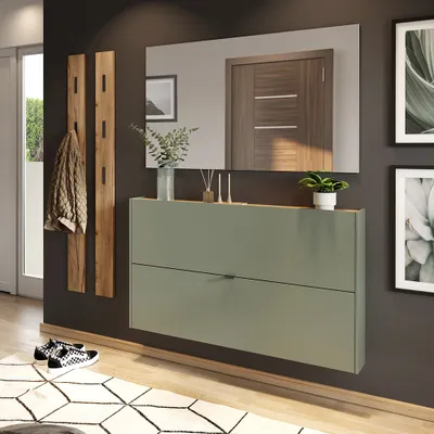 A modern entryway with a green shoe cabinet, wooden coat rack, and mirror.