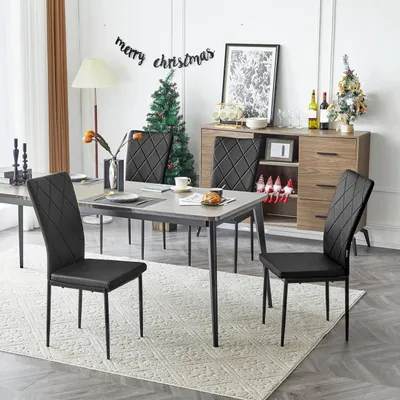 A dining room set up for Christmas, with chairs around a table and a sideboard with decorations.