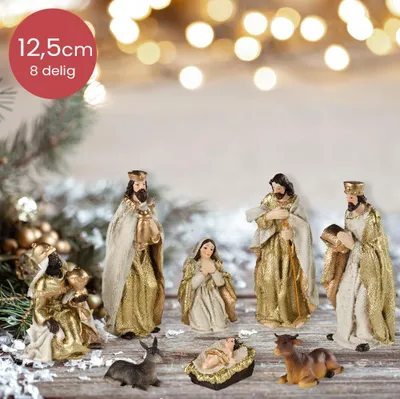 A nativity scene with figurines on a wooden surface, with blurred festive lights in the background.