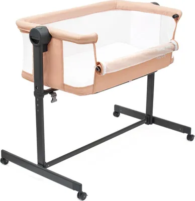 A baby crib with a beige frame and white mattress, on a white background.