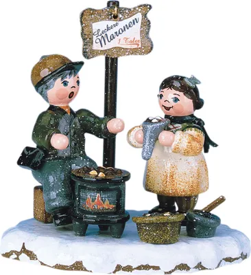 Zwei fröhliche Figuren stehen auf einer schneebedeckten Fläche neben einem kleinen Ofen mit heißen Maronen und einem Schild das leckere Maronen für einen Taler anbietet während sie sich warm anziehen und lächeln