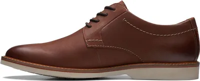 A side view of a brown leather business shoe.