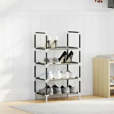 A four-tier shoe rack filled with various shoes, standing against a white paneled wall.