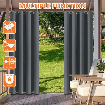 Outdoor curtains hanging on a porch or patio, with a backyard visible through them.
