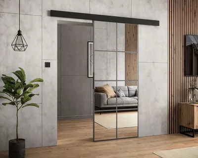 A modern interior with a sliding door with mirror panels, reflecting a living room with a sofa.