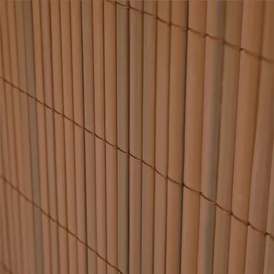 A close-up view of a brown PVC privacy screen made of vertical bamboo-like rods held together by string.