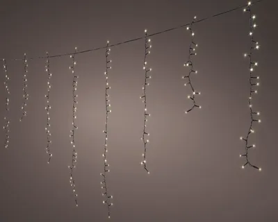 A string of LED lights hanging from a wire against a plain background.