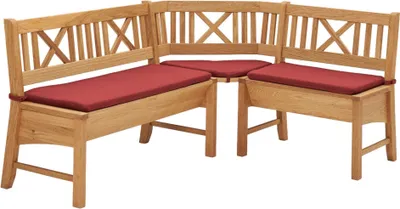 A corner bench with red cushions against a white background.