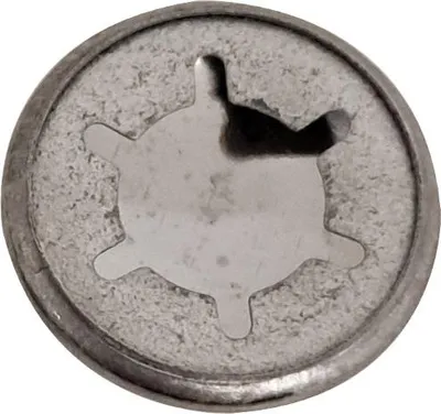 A close-up view of a metal cap with a star-shaped indentation.