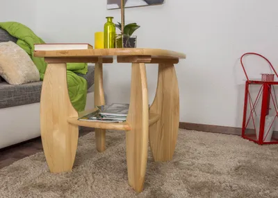 A wooden side table is placed on a rug next to a sofa and a red lantern.