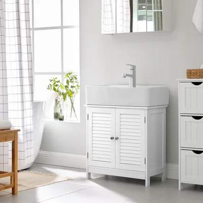 A white bathroom vanity with a sink and faucet, next to a window with a checkered curtain and a bathtub.