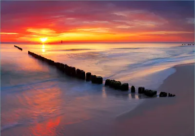 Produktbild von Wallario Fototapete Vliestapete, seidenmatte Oberfläche, einfache Verarbeitung, Größe 200 x 140 cm, Motiv Farbenspiel im Himmel - Sonnenuntergang am Strand