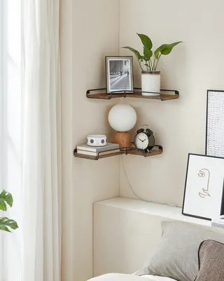 Two corner shelves are mounted on a wall, displaying various decorative items and books.
