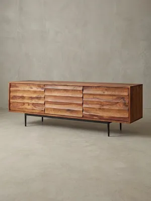 Frontale Ansicht des 147x50x38cm großen Massivholz TV Lowboards im Studio. Die warme rotbraune Farbe des Sheeshamholzes harmoniert perfekt mit dem schwarzen Eisengestell._#sku_BARWL5.636#