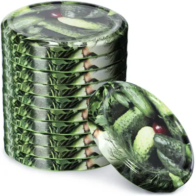 A stack of jar lids with a pickle pattern and one lid in front of the stack.