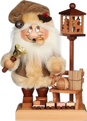 A wooden Christmas figurine of Santa Claus holding a bell and smoking a pipe, standing next to a small wooden train and a bench with gifts.