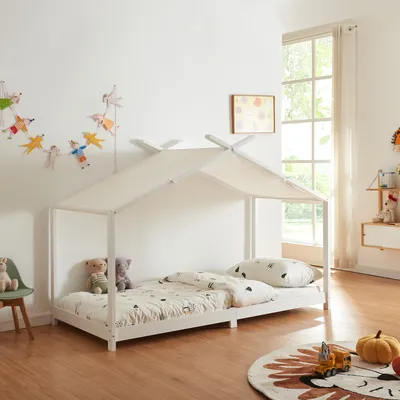 A child's bedroom with a house-shaped bed, toys, and decorations.