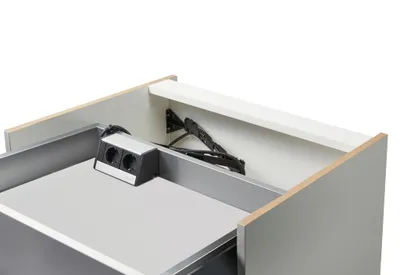 A close-up view of a built-in power outlet unit inside a cabinet drawer.
