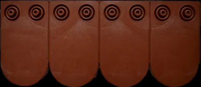 Four brown roof tiles arranged in a row against a black background.