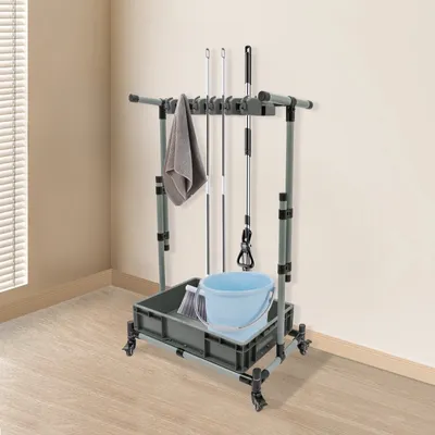 A cleaning cart with mops, a broom, and a bucket is shown in a room with light-colored walls and blinds.