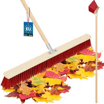 A broom is shown sweeping a pile of colorful autumn leaves.