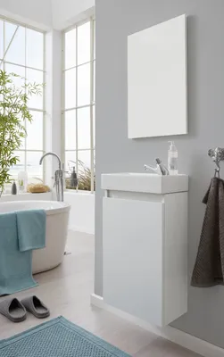 A modern bathroom with a freestanding bathtub, a wall-mounted vanity with a sink, and a large window.