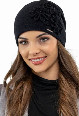 A woman wearing a black winter hat with floral embellishments.