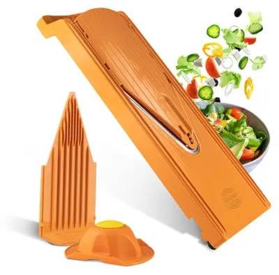A kitchen slicer with some chopped vegetables flying into a bowl of salad.