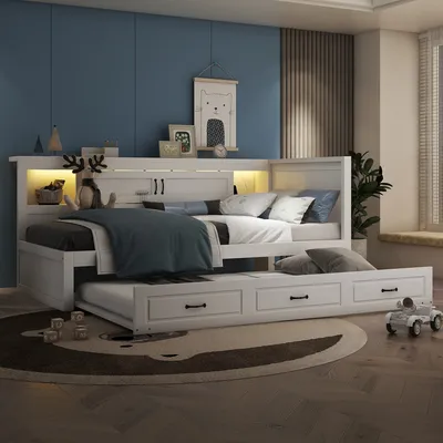 A white daybed with a pull-out trundle bed is set up in a child's bedroom with blue walls and a decorative rug.