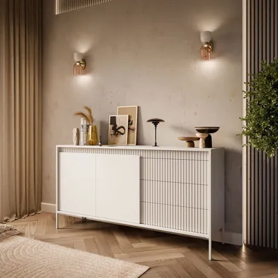 A modern living room with a beige sideboard and decorative items.