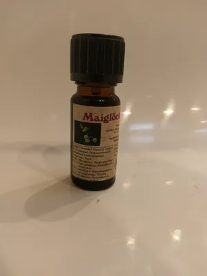 Kleine braune Flasche mit einem schwarzen Verschluss. Auf dem Etikett steht "Maiglöckchen".