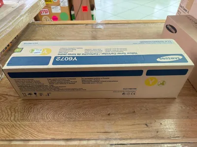 A Samsung toner cartridge box is placed on a wooden surface.