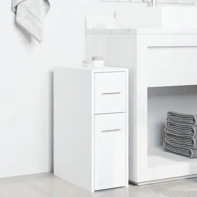 A white bathroom cabinet with drawers and a door, placed next to a larger white vanity unit with towels stacked on a shelf.