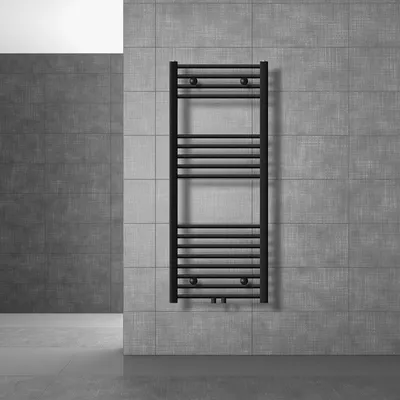 A black radiator is mounted on a gray tiled wall in a modern bathroom setting.